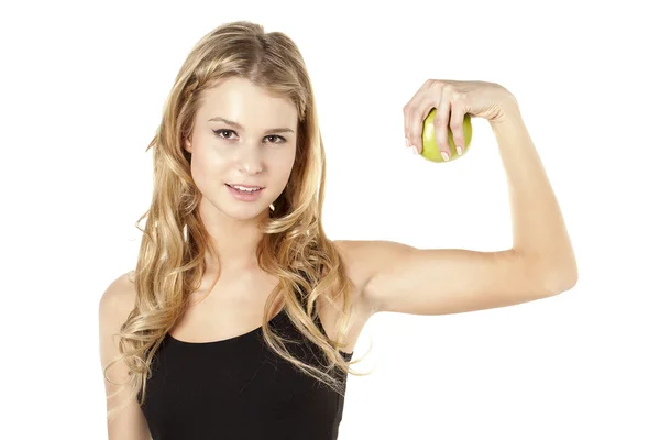 Portrait of beautiful woman holding green apple and flexing musc — Stock Photo, Image