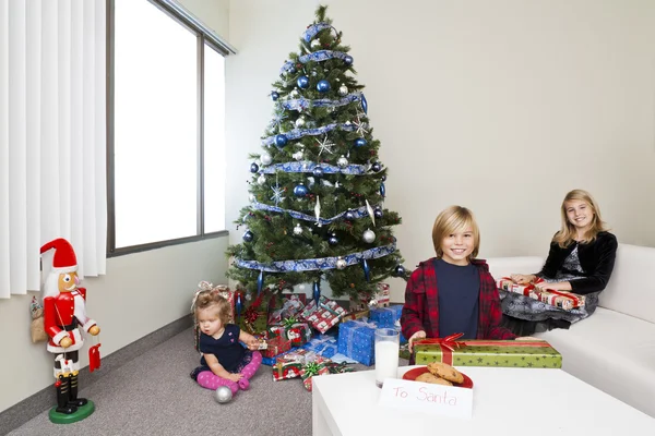 Imagen de hermano y hermana con una linda niña sentada en el piso con