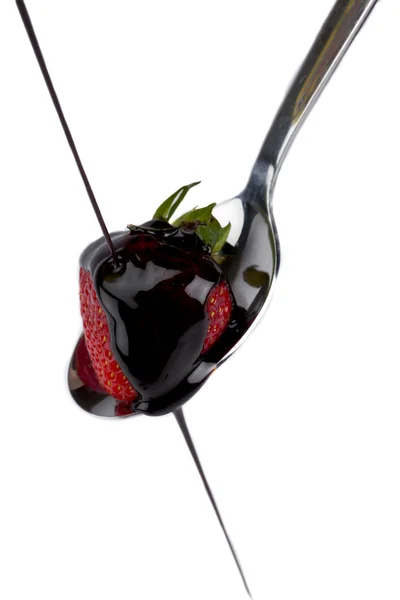 Portrait de fraise sur une cuillère versant un chocolat fondu — Photo