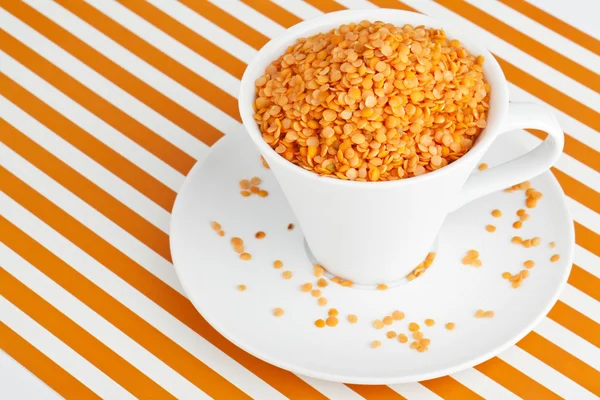 Чашка апельсиновой чечевицы на тарелке — стоковое фото