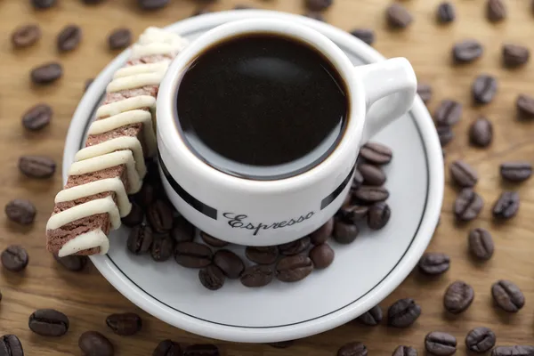 Tasse de café noir et haricots avec des jetons — Photo