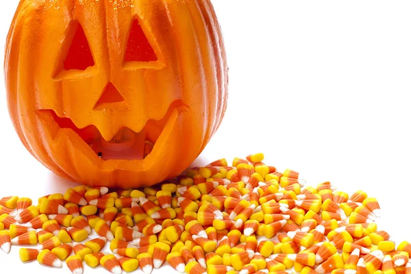 Carved pumpkin on pile of candy corn — Stock Photo, Image