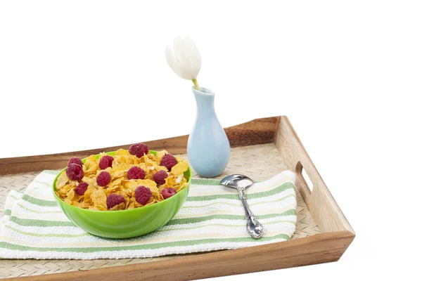 Cornflakes-Schale auf einem Holztablett mit weißer Blumenvase — Stockfoto