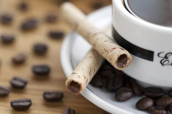 Cup and saucer coffee beans with cookie sticks — Stock Photo, Image