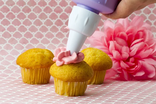 Image du sac de glaçage serrant la cerise sur le cupcake — Photo