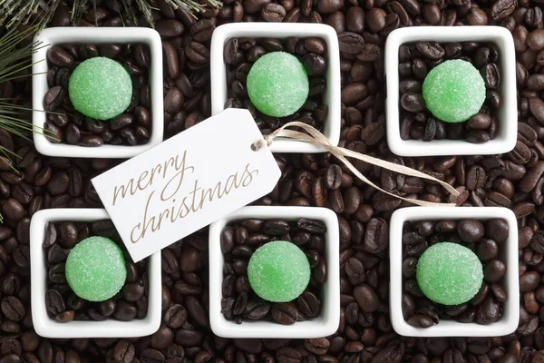 Merry christmas tag with coffee beans and candies — Stock Photo, Image