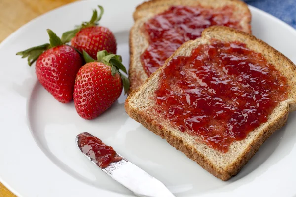 Scheibe Brot mit Erdbeerfrüchten und Marmelade — Stockfoto