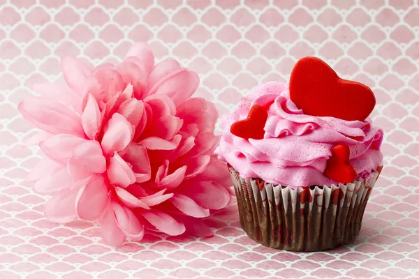 Blick auf Erdbeer-Cupcake mit Herzform und rosa Blume — Stockfoto