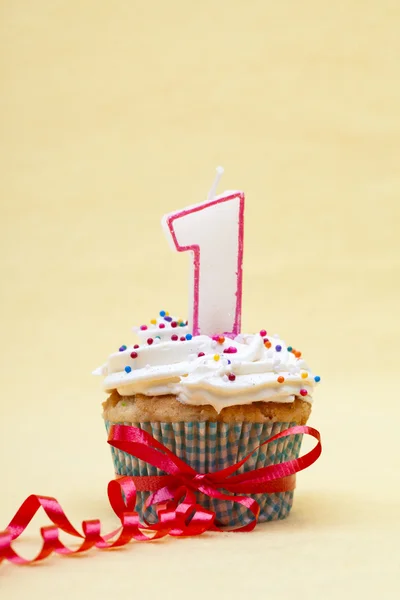 Close up image of a cupcake with number 1 candle and streamer — Stock Photo, Image