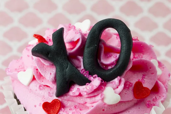 Close up tiro de um cupcake com um símbolo xo embutido no icin — Fotografia de Stock