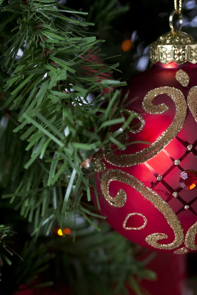 Cropped view of shiny red christmas bulb hanging on christmas tr — Stock Photo, Image