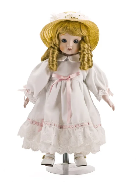 Pequena boneca no vestido branco e chapéu — Fotografia de Stock