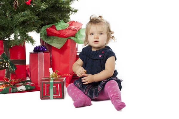 Portret van een lief meisje zitten door kerstboom en Kerstmis — Stockfoto