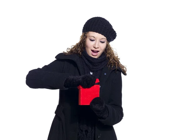 Donna in abbigliamento invernale aprendo il suo regalo di Natale — Foto Stock