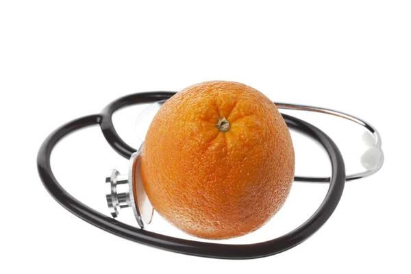 Закройте апельсин со стетоскопом на белом — стоковое фото