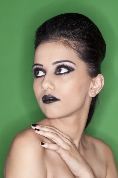 Aantrekkelijke jonge vrouwelijke donkere dragen make-up met hand op moet — Stockfoto