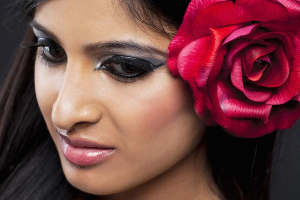 Close up tiro de uma mulher com uma rosa no cabelo — Fotografia de Stock