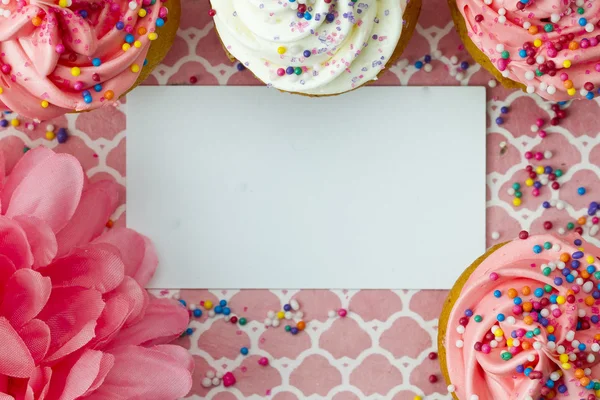Vue du dessus de la plaque vide avec cupcakes et fleur — Photo