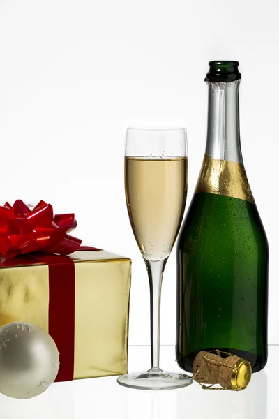 Champagne flute and bottle with christmas gift — Stock Photo, Image