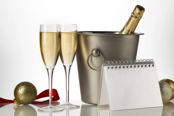 Champagne bottle flutes and ice bucket with christmas baubles — Stock Photo, Image