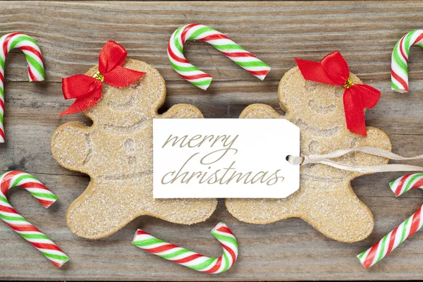 Imagen de una mujer caramelos de pan de jengibre con una etiqueta de Navidad feliz — Foto de Stock