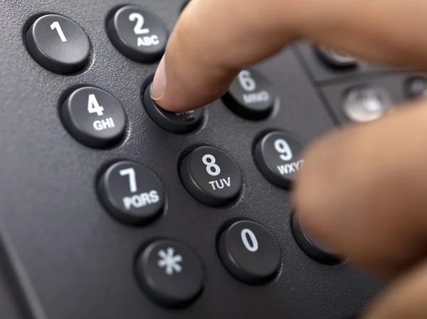 Primer plano de dedo humano presionando número de teléfono fijo —  Fotos de Stock