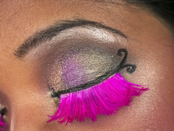 close up shot of females eye with mascara pink eye lashes and ey