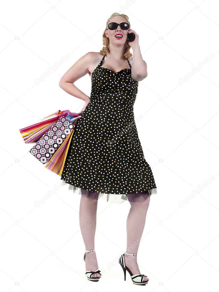 portrait of a woman holding shopping bags and talking on phone