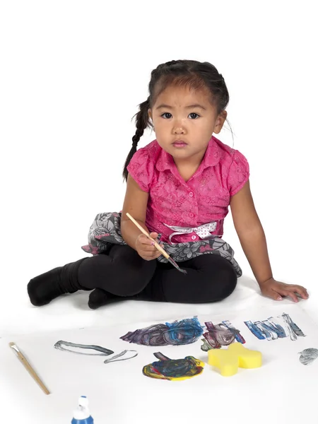 Portrait of cute girl with paint brush and paper — Stock Photo, Image
