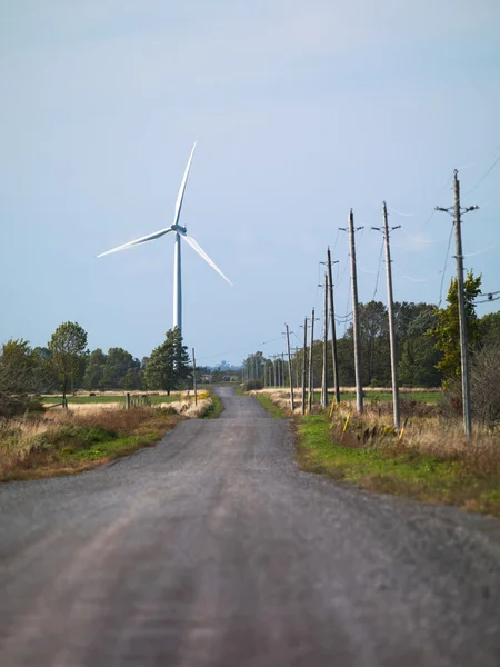 Camino con molino de viento en el fondo —  Fotos de Stock