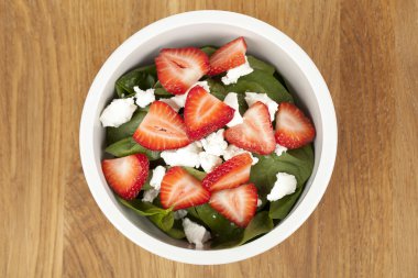 Ispanaklı salata bir kase çilek dilimleri ile