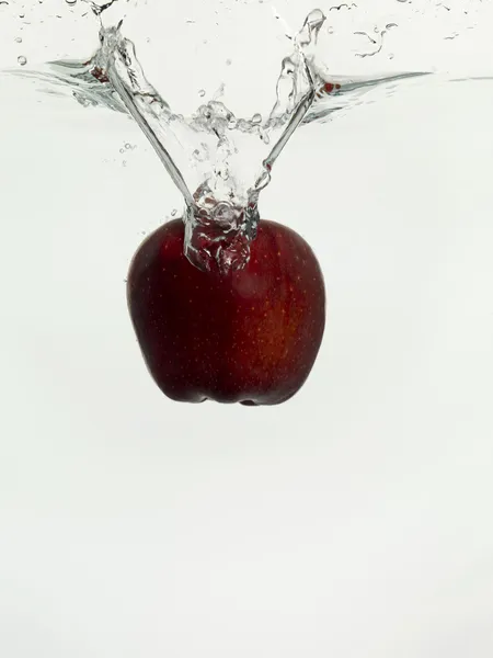 Apfel fällt auf klares Wasser — Stockfoto