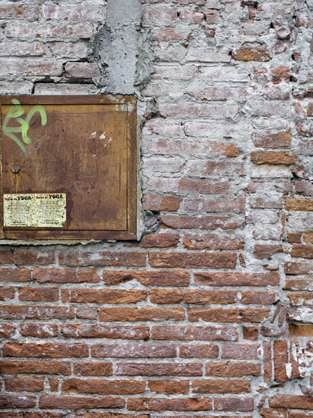 Bakstenen muur met een houten venster — Stockfoto