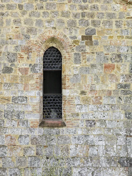 Arch window on stone wall of a tuscan church — Stock Photo, Image