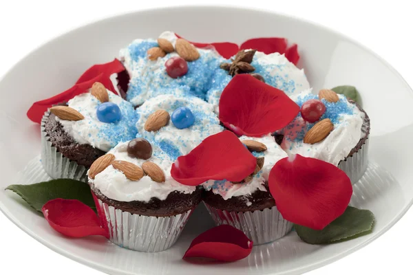 Close up image of chocolate cupcakes with rose petals