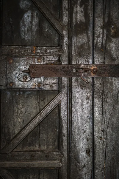 Porta de madeira com um bloqueio enferrujado — Fotografia de Stock