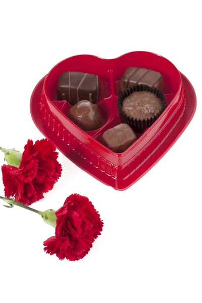 Chocolates in heart shape box with red flowers — Stock Photo, Image