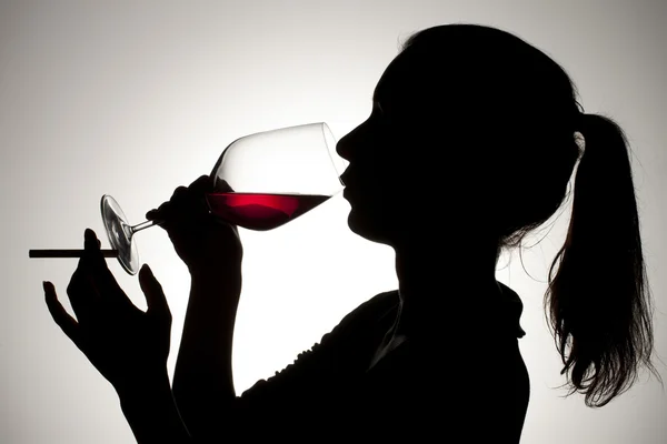Žena pít červené víno při kouření — Stock fotografie