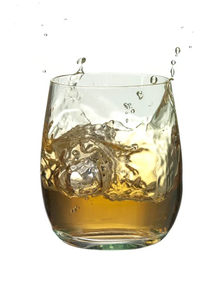 Ice cube splashed into the glass of brandy — Stock Photo, Image