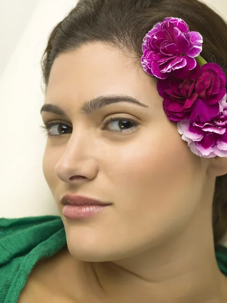 Mujer encantadora con flores en la oreja — Foto de Stock