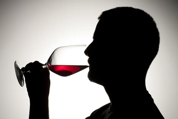 Silhouette of a man sipping wine — Stock Photo, Image