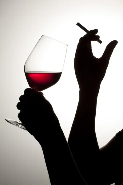 Silhouette of woman drinking wine with cigarette — Stock Photo, Image