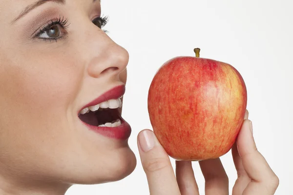Women biting into fresh apple closeup on white background — Stock Photo, Image