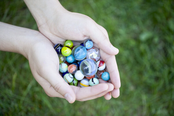 a hand with colorful marbles