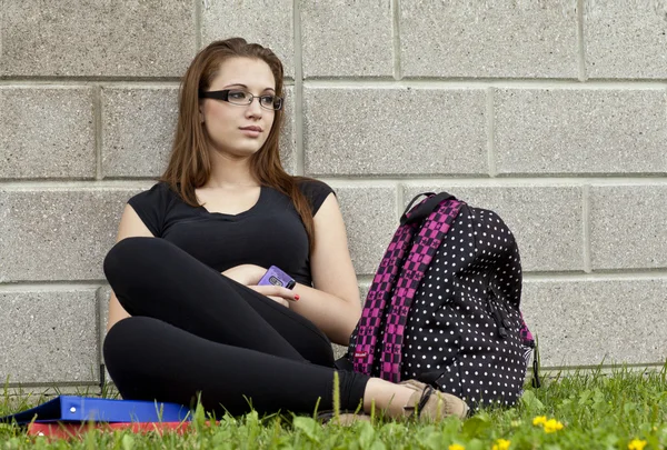 Menina adolescente pensativo segurando celular — Fotografia de Stock