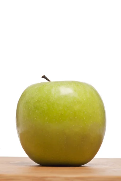 Green apple on a wooden plank — Stock Photo, Image