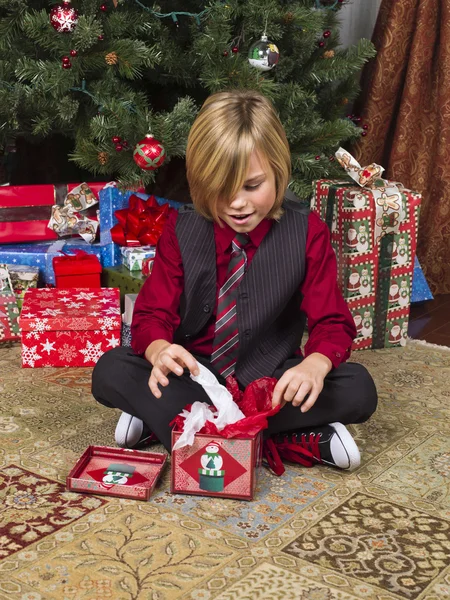 Blond pojke uppackning hans julklapp — Stockfoto