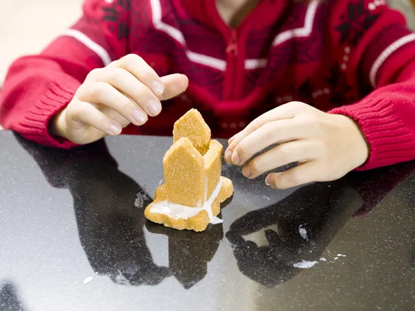 Close up of a pre adolescent boy making gingerbread house — Stock Photo, Image