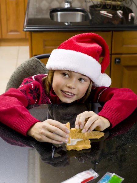 Cute boy looking away while making gingerbread house — Stock Photo, Image