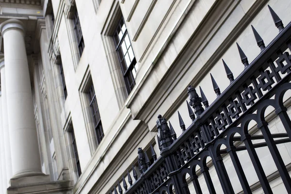 Low angle shot of wrought iron fence with a structure in backgro — Stock Photo, Image